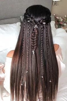 Half-up style with fine braids threaded through long straight hair and scattered crystal pins