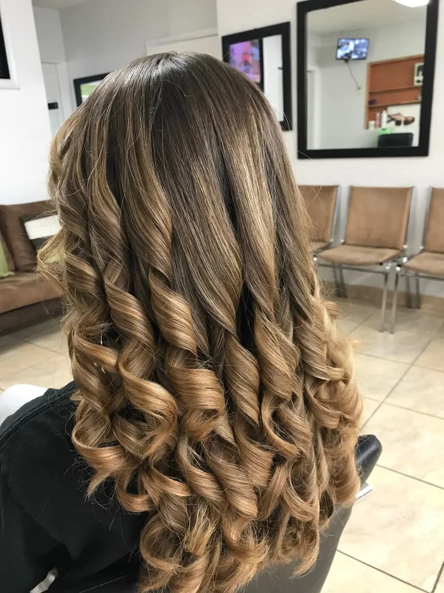 Spiral curls set from mid-length down, on hair with warm caramel highlights