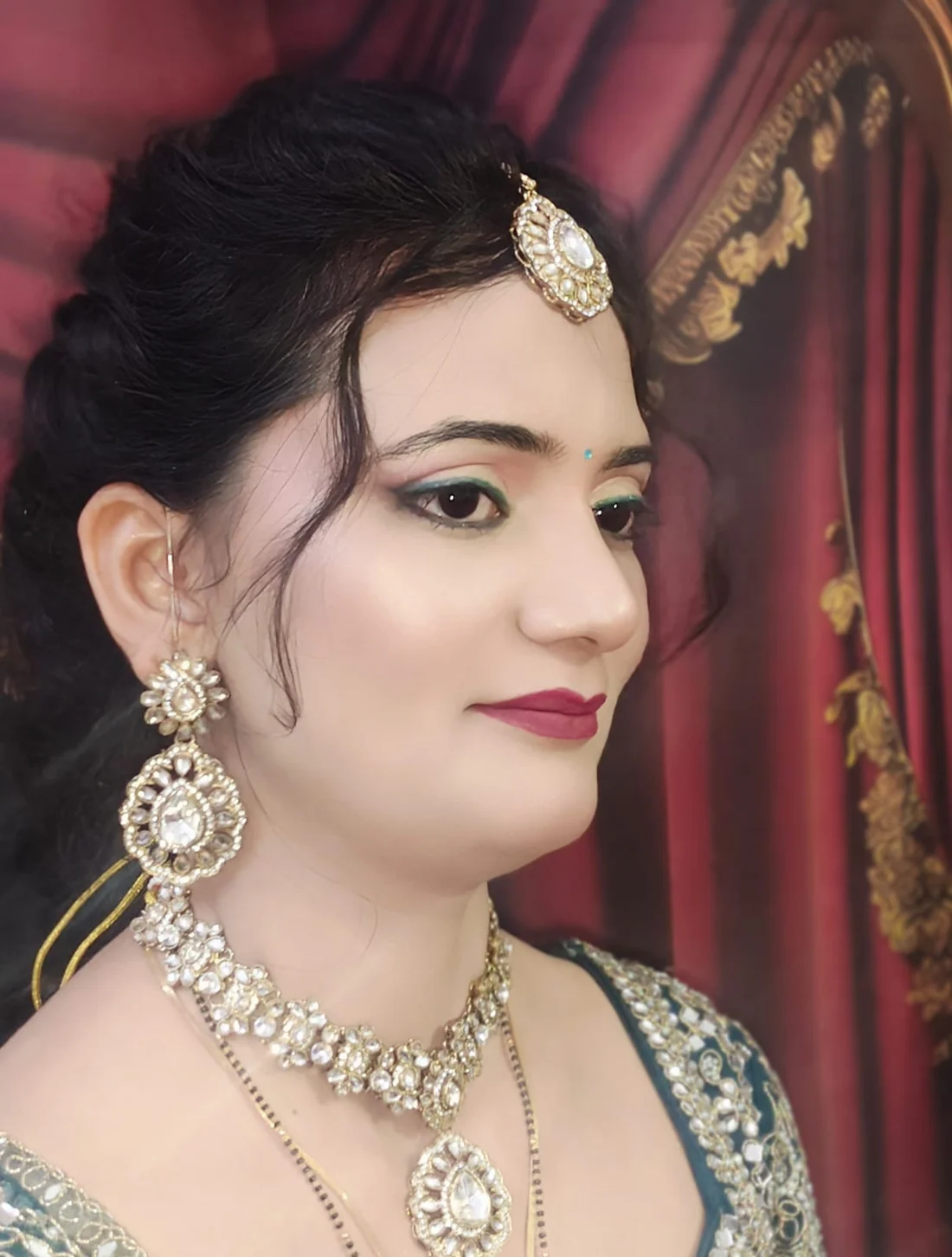 Engagement look with a teal-accented eye, maang tikka and layered kundan jewellery