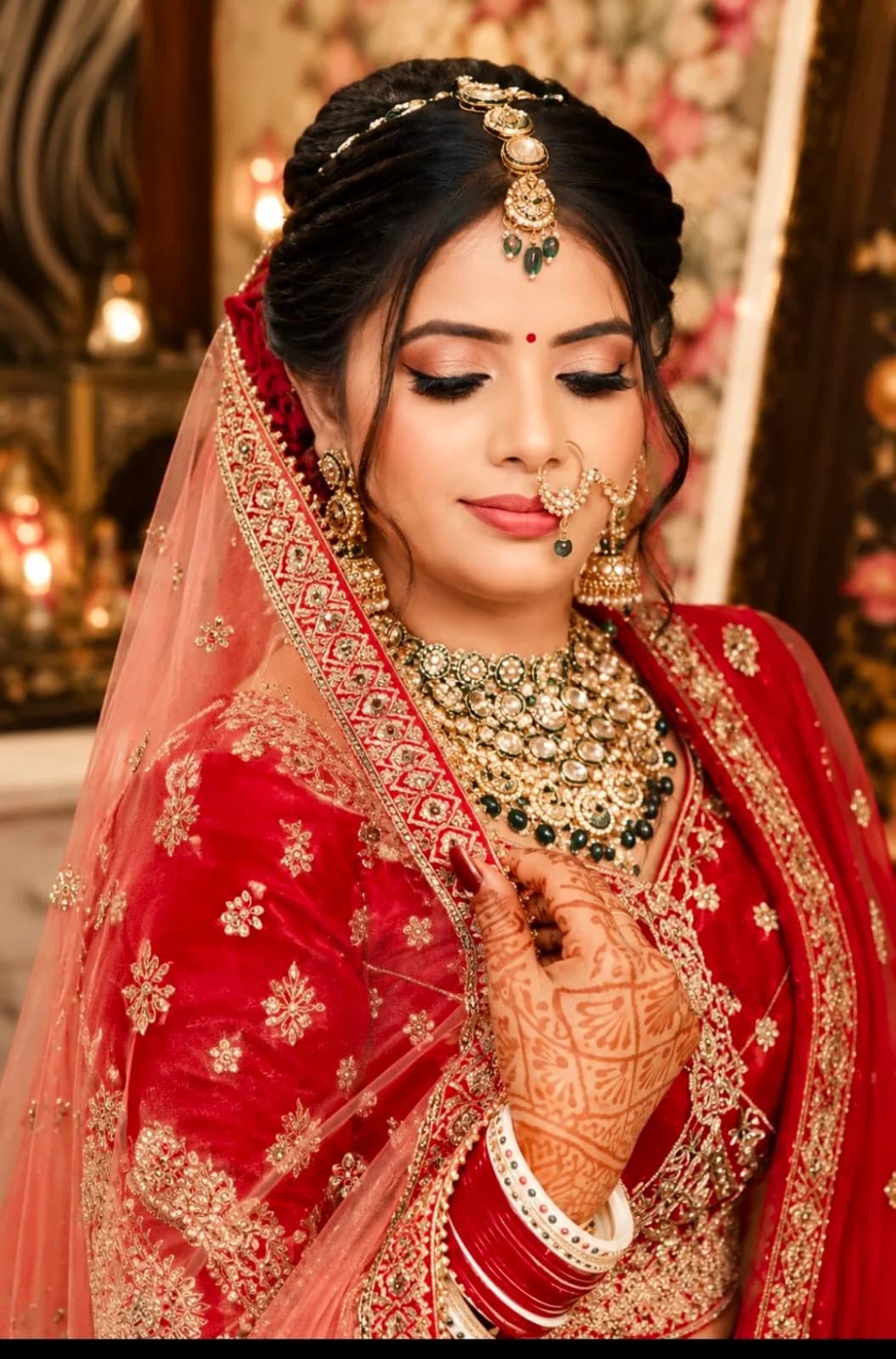 Bridal look in red and gold with a sculpted eye and emerald kundan jewellery