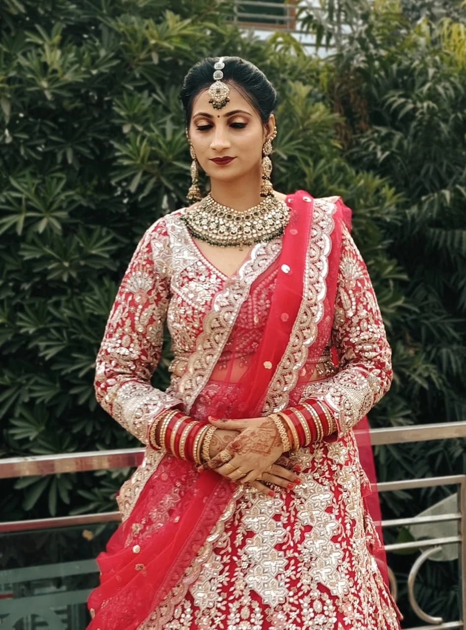 Bridal look in red and silver with a kundan choker and maang tikka, photographed outdoors