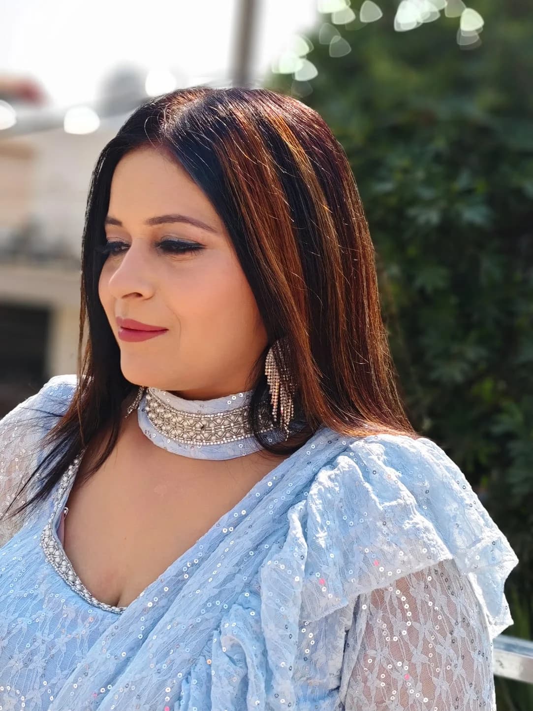 Soft occasion makeup with a smoky liner, worn with a powder-blue sequinned outfit
